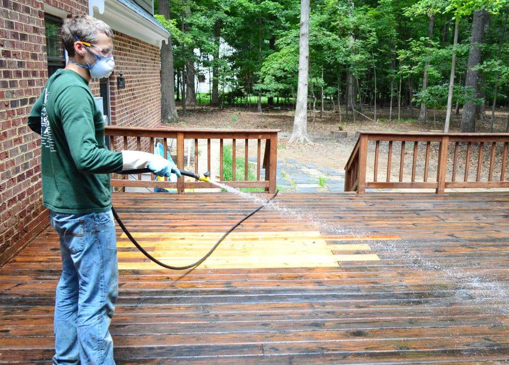 John rinsing stripper finish off of wood deck