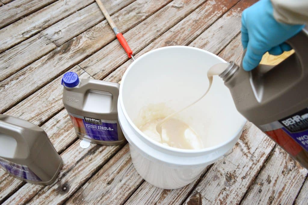 Pouring deck stripper into a bucket