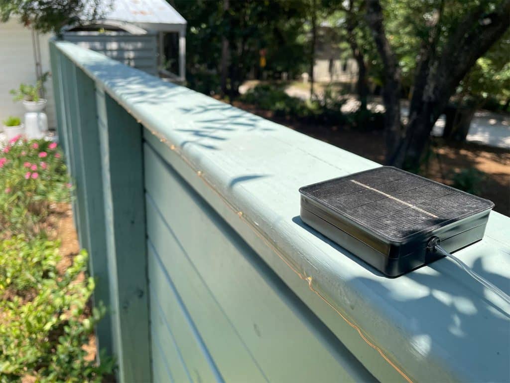 Small Solar Panel Sitting On Top Of Fence For LED Solar Lights