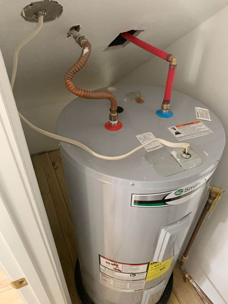 Before Photo Of Large Electric Water Heater Tank In Utility Closet