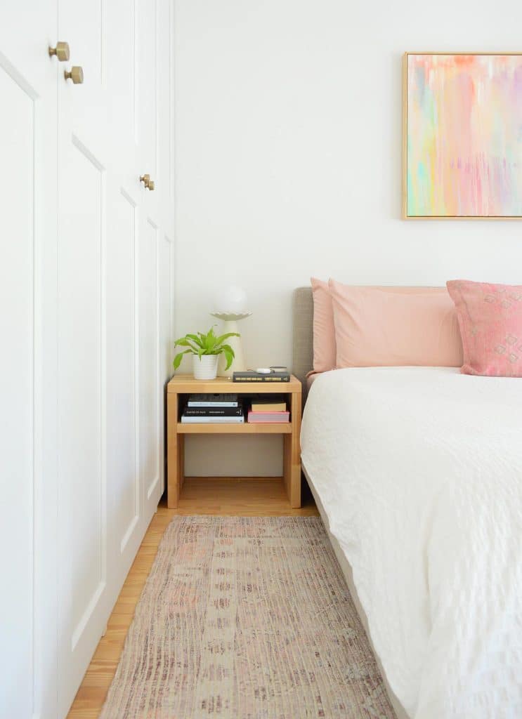 Bedroom With White Ikea Closets Next To White King Bed With DIY Wood Nightstand