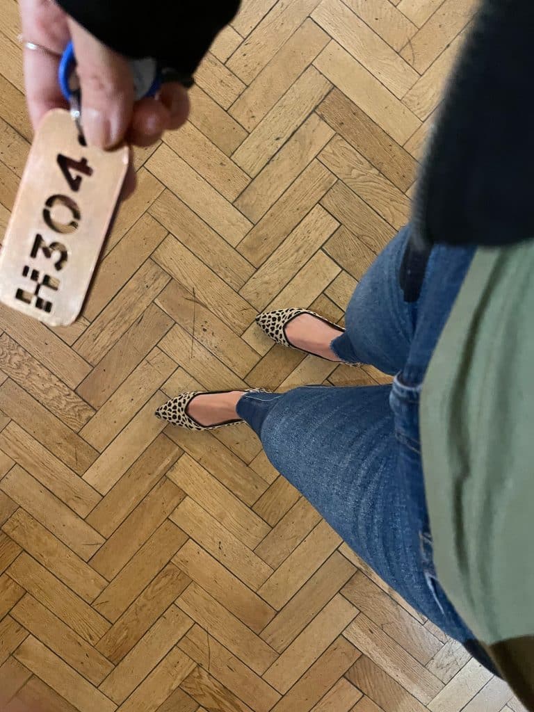 Shot from above at jeans and leopard flats on herringbone wood floor