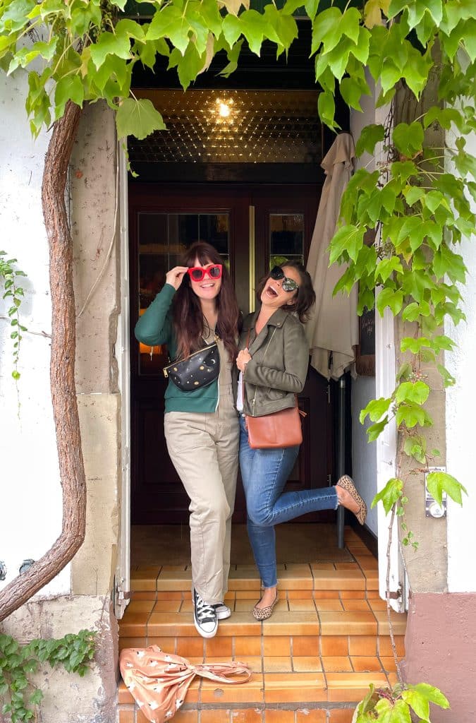 Sherry and Elsie Larson posing in a doorway with green jacket over white tank