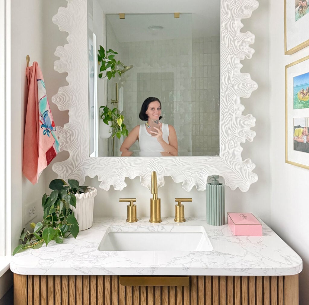 Sherry In Mirror Of Bathroom With Scallop Mirror and Colorful Art
