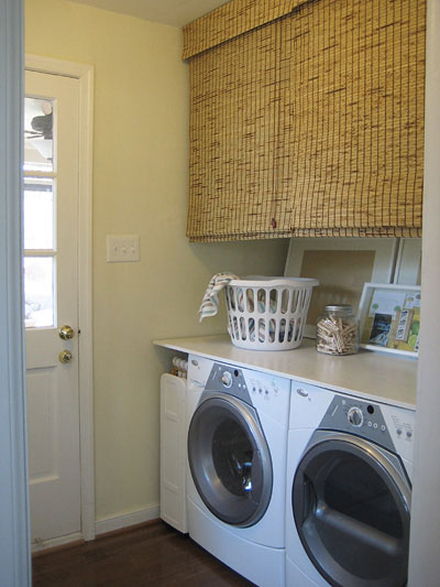 Laundry Closet With Bamboo Roller Blinds To Conceal Storage